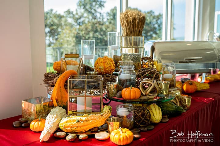 Elegant table setting at our corporate event, adorned with autumn-themed decor including pumpkins, gourds, and candles