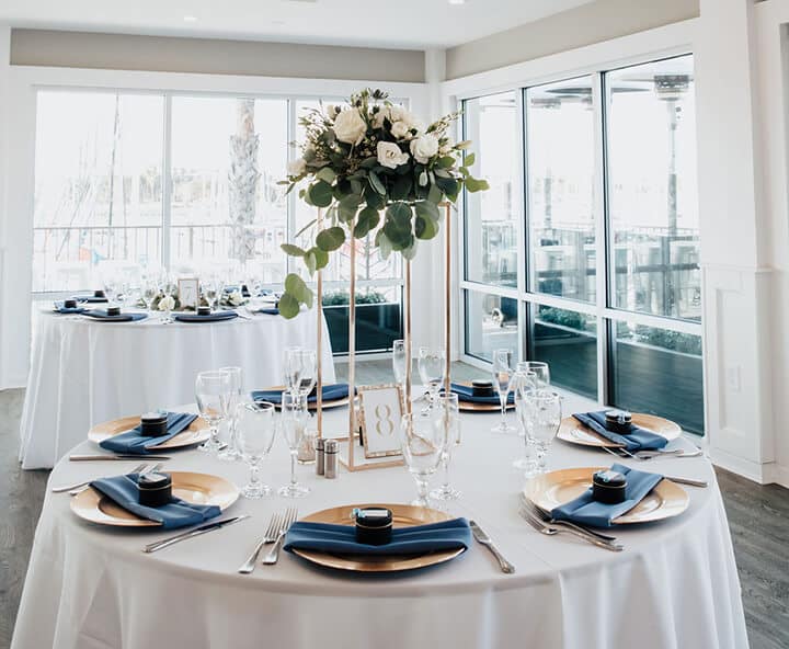 Elegant table setup featuring white table linens and a centerpiece of white roses